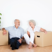 Couple sit on the floor between new boxes used to move house